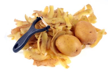 Patates ve soyma beyaz arka plan üzerinde yakın çekim bir sebze soyucu ile 