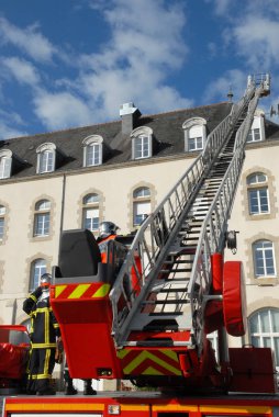 Bir binaya giden bir itfaiye kamyonu büyük merdiven