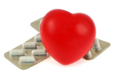 Plastik kalp ilaç pedleri üzerine koydu beyaz arka plan üzerinde yakın 