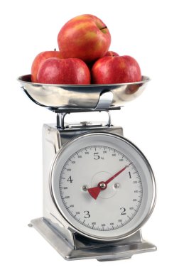 Mutfak terazisindeki elmalar beyaz arkaplanı kapatır