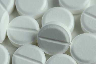 Bulk aspirin tablets close up background clipart