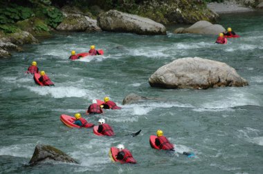 Genç insanlar bir dağ deresinde hidrosiple geziyorlar. 