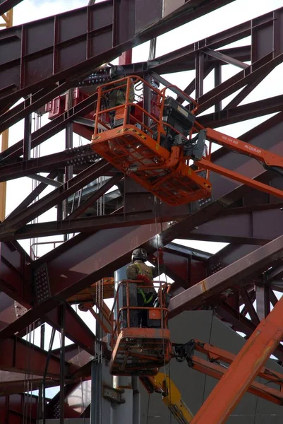 Welders on a construction site with steel beams