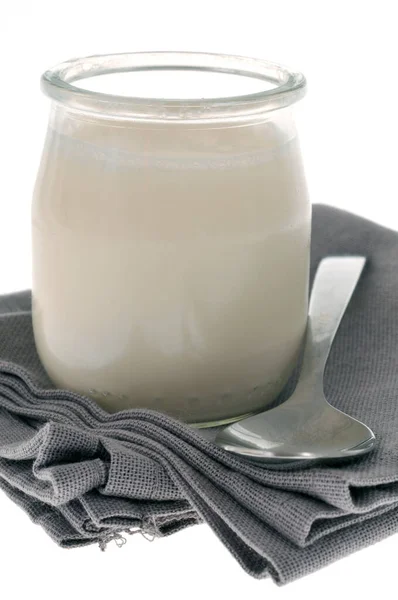 餐巾纸上的玻璃瓶中的纯酸奶 — 图库照片