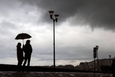 Saint-Jean de Luz 'da yürüyen şemsiyeli bir çift.