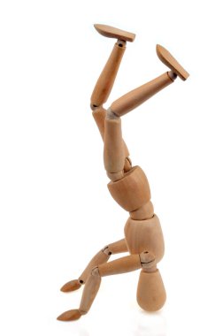 Tahta eklemli manken, beyaz arka planda kafa üzerinde dengelenmiştir. 