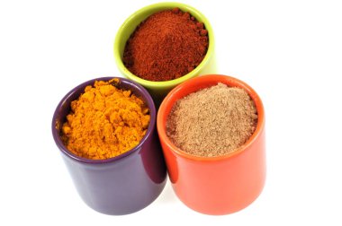 Beyaz arka planda zerdeçal, zencefil ve kırmızı biberin ramekinleri 