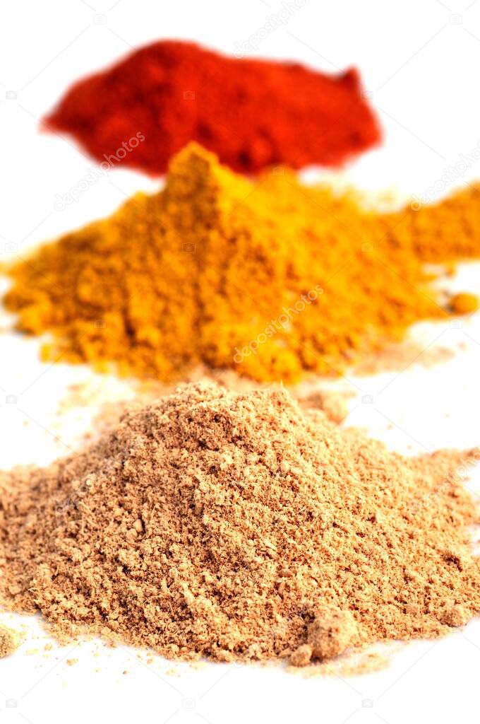 Ginger, curry and paprika in bulk close-up on white background 