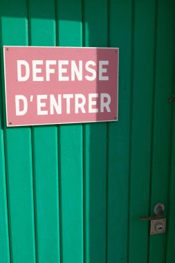Fransızca giriş yasak yazan bir kapıyı imzalayın.