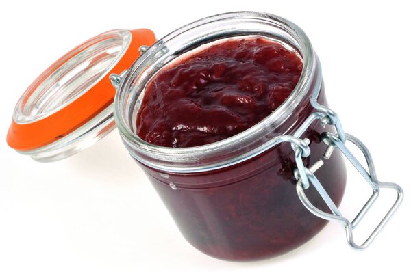 Банка домашнего клубничного варенья крупным планом на белом фоне