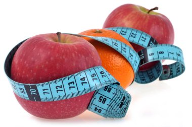 Elma ve turuncu beyaz arka planda esnek bant ölçüsüyle çevrili.