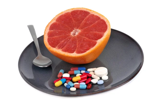 Тарелка Разрезанным Розовым Грейпфрутом Руке Лекарствами Крупным Планом Белом Фоне — стоковое фото