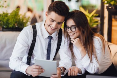 İki genç insan tablet ile kafede gün için plan tartışıyor