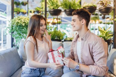 güzel kadın gül ve sürpriz veren genç yakışıklı adam