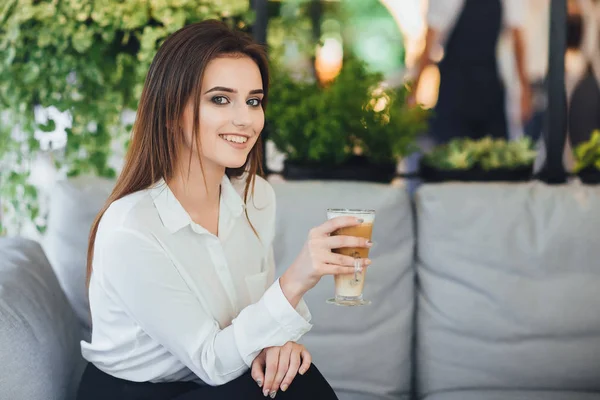 Ofiste oturan Beyaz gömlekli elinde kahvesiyle genç iş kadını