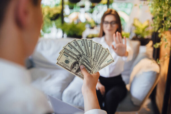 man offering woman bribe, selective focus