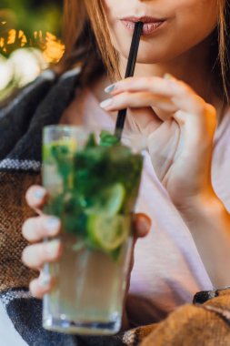 Görünüm içinde rahat kıyafetler içme kadın yaz terasında kokteyl kırpılmış  