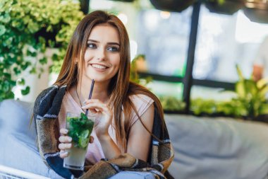 Genç kadın rahat kıyafetler yaz terasında kokteyl içme  