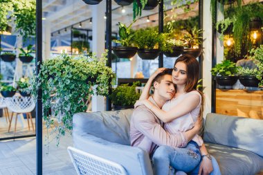 Genç çift kafede yaz terasında sarılma