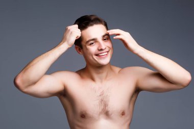 gri arka plan üzerinde kafa tutan genç yakışıklı adam