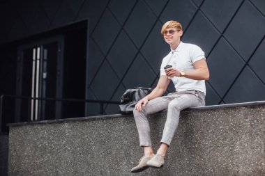 Genç sarışın adam güneş gözlüğü ve beyaz gömlek dört gözle 