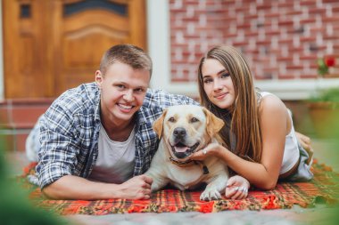 Courtyard adlı köpek, dinlenme mutlu gülümseyen çift odaklanmak tutulur