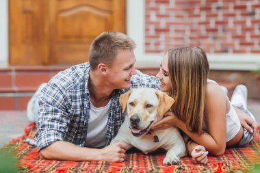 Çift courtyard adlı köpek ile dinlenme gülümseyen, ön plan üzerinde odaklanmak