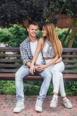 Parkta bankta oturmuş ve birbirine bakarak genç Çift