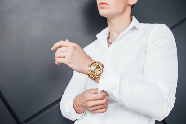 Expensive gold watch on hand of businessman in white shirt, cropped view