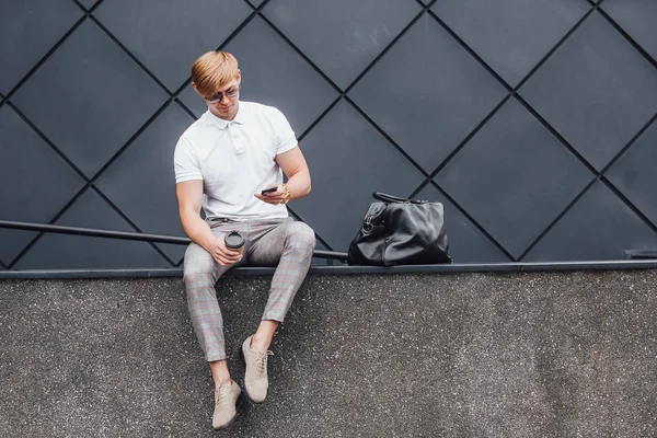 Hombre Gafas Sol Camisa Blanca Mirando Smartphone Con Taza Café — Foto de Stock