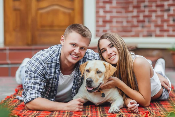 Mutlu çift courtyard adlı köpek ile dinlenme gülümseyen