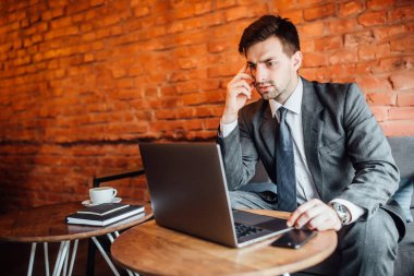 ciddi seyir dizüstü bilgisayar ve kafa yakınındaki el tutmak işadamı