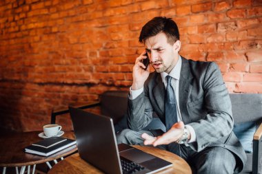 Smartphone üzerinde konuşmak ve dizüstü arıyorum iş adamı