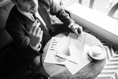 işadamı Divan kafede oturan belgelerle elbiseli kırpılmış görünümü 