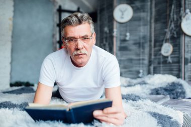 Ciddi ve duygusal bir adam okuma kitabı yatak odasında 