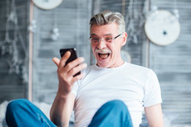 mutlu adam yatağa rahatlatıcı ve telefon haber okuma sakallı