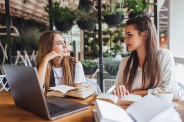 İki öğrenci ödev kafede dizüstü bilgisayar ile