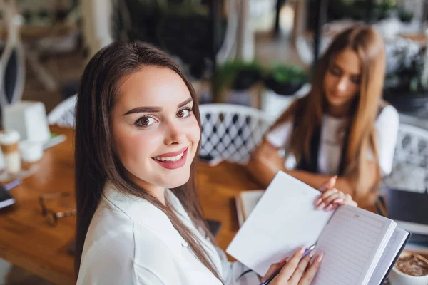 Brunett Tjej Skriva Ord Häfte Och Tittar Kameran Fokus Förgrunden — Stockfoto