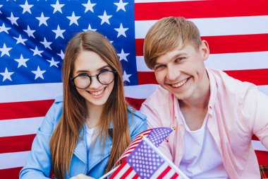 Amerikan bayrağının arka planında genç çift 