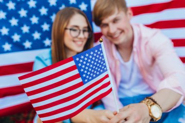 Amerikan bayrağının arka planına karşı genç çift, seçici odaklanma