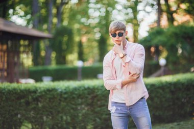 Kameraya poz veren sıradan giysili genç yakışıklı adam.