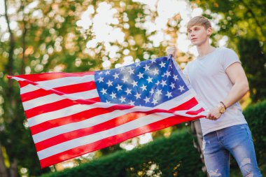 bulanık arka plan üzerinde Amerikan bayrağı ile yakışıklı adam