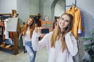 İki genç kadın ile hediye çanta alışveriş merkezine sonra indirim sertifika alma