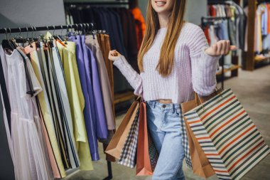 Alışveriş torbaları showroom üzerinde yürüme ile mutlu gülümseyen kadın