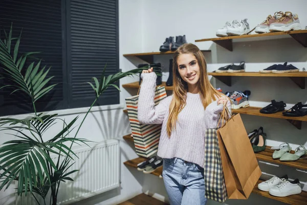 Ung Glad Kvinna Med Shoppingkassar Poserar Rack Med Skor — Stockfoto
