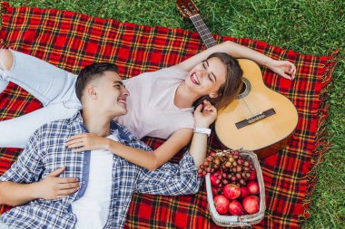 Genç ve güzel bir çift battaniye halısında eğleniyor. 