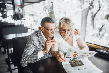 üst düzey çift kahve bekleyen, yaz terası ve gazete okuma 