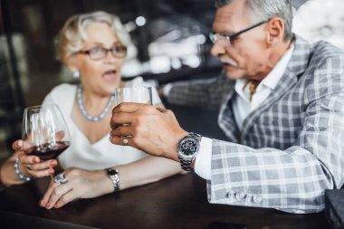 Dişi kırmızı şarapta odak yaz terasında adam arka planda eller.