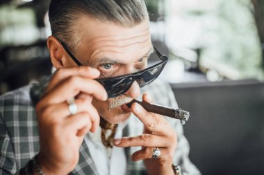 Yaşlılar sigara konsantre ve ileriye dönük adam 