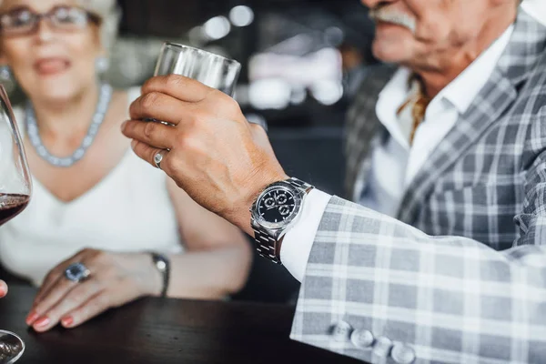 yaz terasında şarap adamla tutan gülümseyen kadın görünümünü kırpılmış